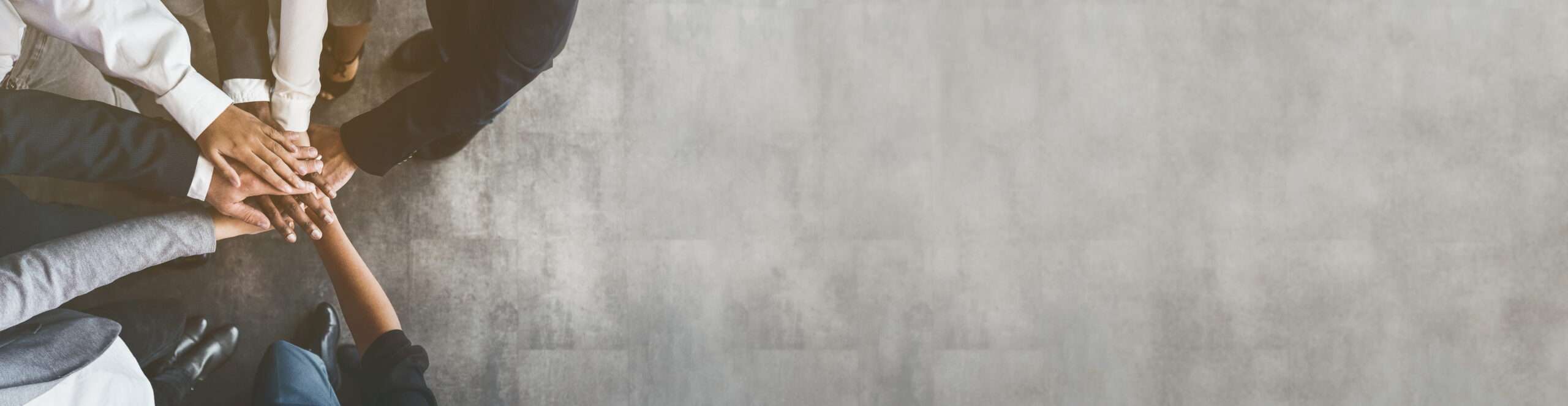 Business team putting their hands together, top view